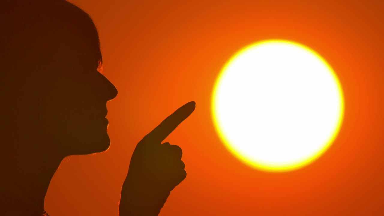 여성 (실루) 은 밝은 태양과 하늘 배경에 서 있습니다. 가게