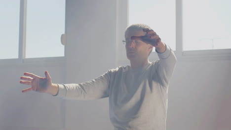 hombre practicando movimientos de tai chi con los ojos cerrados