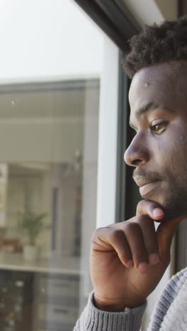 video of thoughtful african american man looking outside window