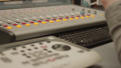 a person adjusting an audio mixer