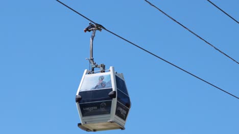 seilbahn, die sich durch den klaren blauen himmel bewegt