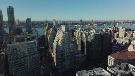 Slide-and-pan-footage-of-multistorey-apartment-houses-in-residential-district-at-riverbank.-Manhattan,-New-York-City,-USA