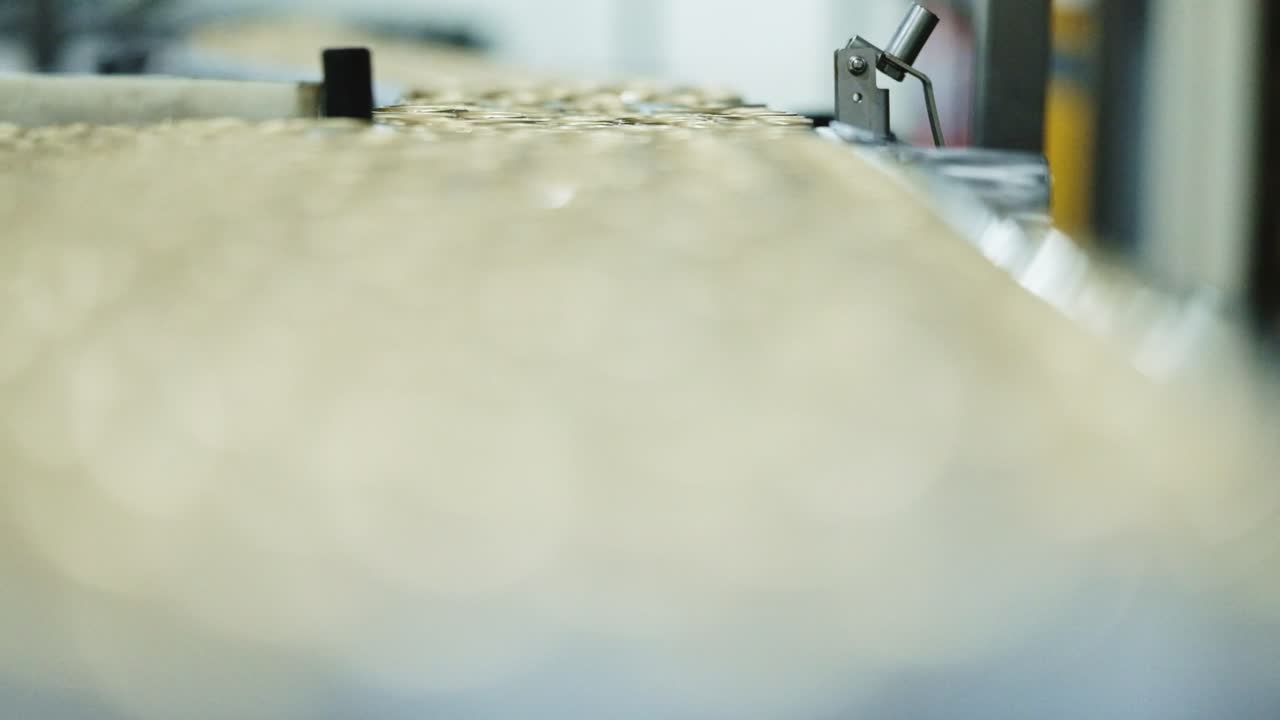 Close up of beverage cans moving along a production line in a factory