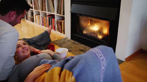 Couple-relaxing-near-fireplace-in-living-room