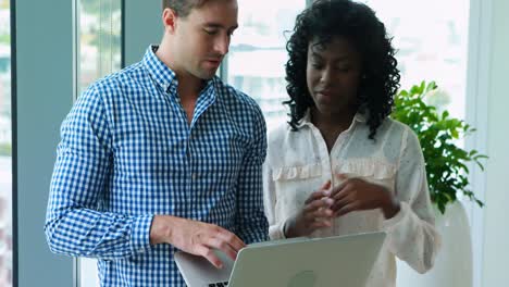 executives discussing over laptop in office