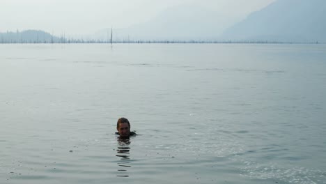 Vorderansicht-Eines-Jungen-Kaukasischen-Mannes,-Der-Im-Stadtfluss-Schwimmt,-4k