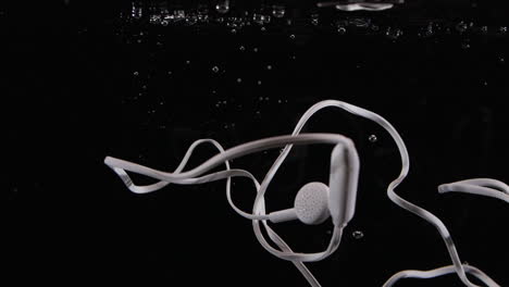 los auriculares del teléfono se hunden en el agua con burbujas a prueba de agua