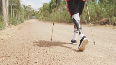 sporty mixed race man with prosthetic leg hiking