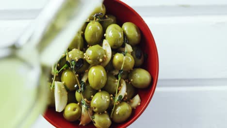 aceite de oliva que se vierte en tapas de oliva verde