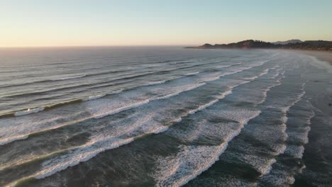 calma alta antena de olas estrelladas a lo largo de la playa, escena de puesta de sol pacífica
