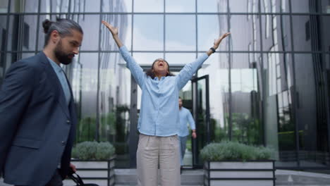 winning business lady screaming raising hands up in crowded office city center.