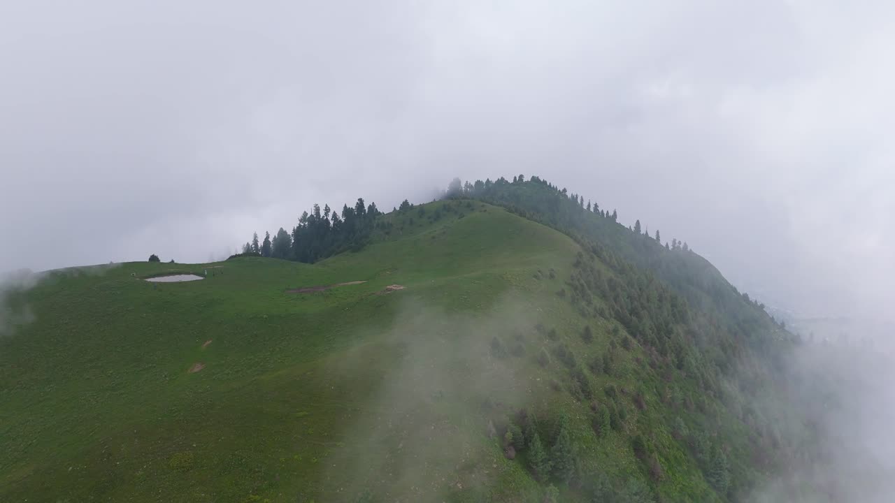 Cloudy Green Fields and Misty Peaks of Kuna Dana Peak Aerial Footage