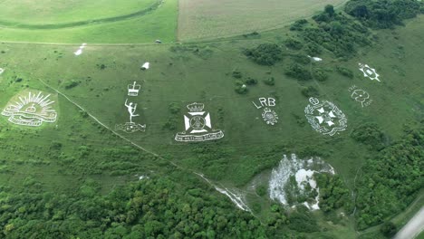 orbiting aerial view above fovant military badges carved into the wiltshire chalk hill farmland countryside landmark