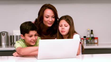 Madre-Usando-Una-Computadora-Portátil-Con-Sus-Hijos-En-La-Cocina