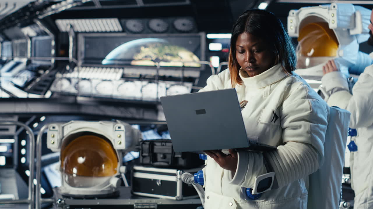 Astronaut monitoring systems on laptop during human expansion in space