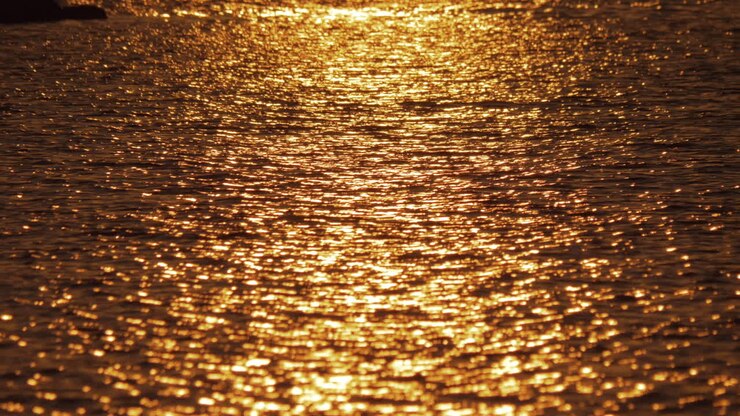 Dark water with golden sun path