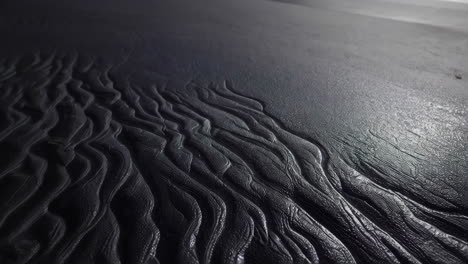 black sand beach with wave patterns