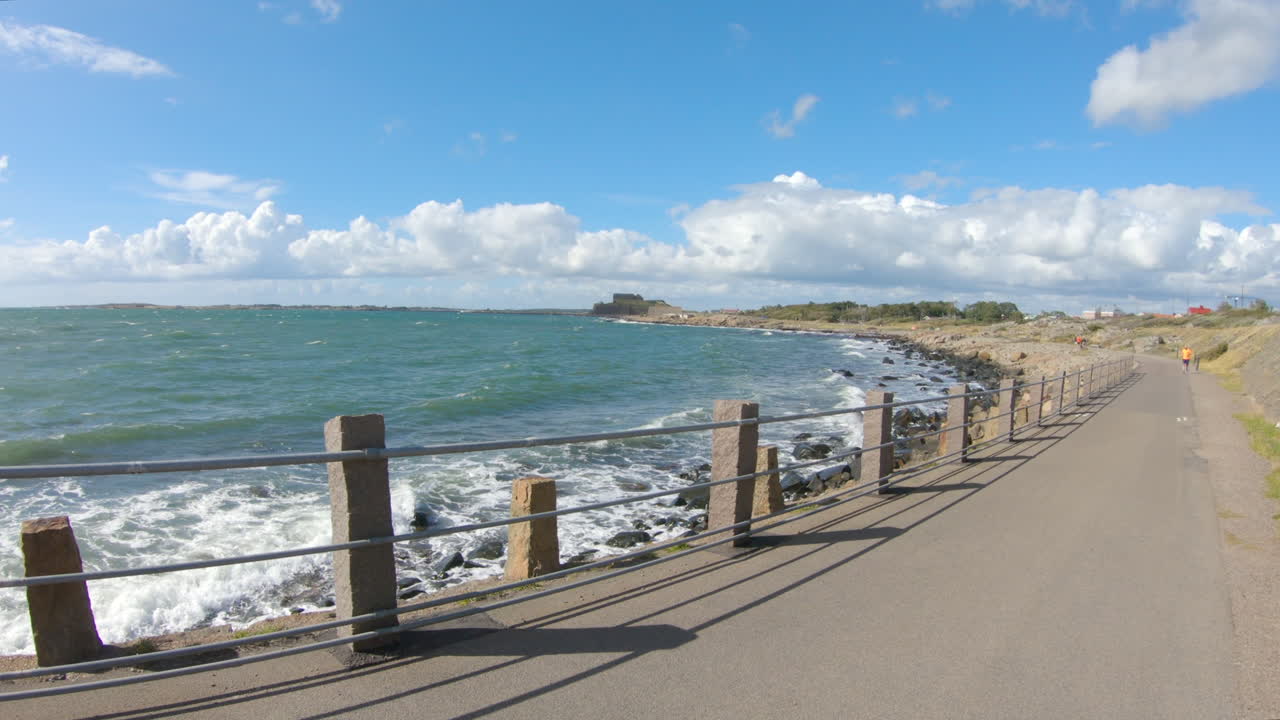 4k Shot of a curved path next to blue ocean sea at Varberg, Sweden