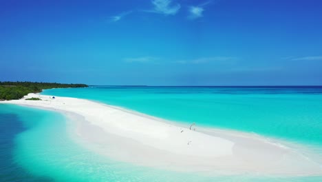 paradise tropical island with long stripe of white sandy beach surrounded by blue azure sea water under a bright blue sky in maldives