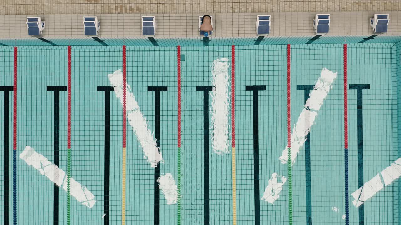 올림픽 수영장에서 점프하는 남자의 탑 샷