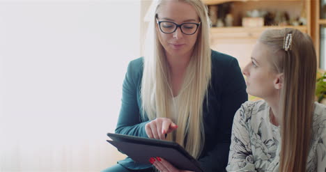 Two-Women-Working-On-A-Project-On-Digital-Tablet-At-Home-Office