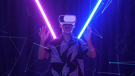 vr, futuristic, entertainment concept. excited asian boy using virtual reality headset with neon light at the background