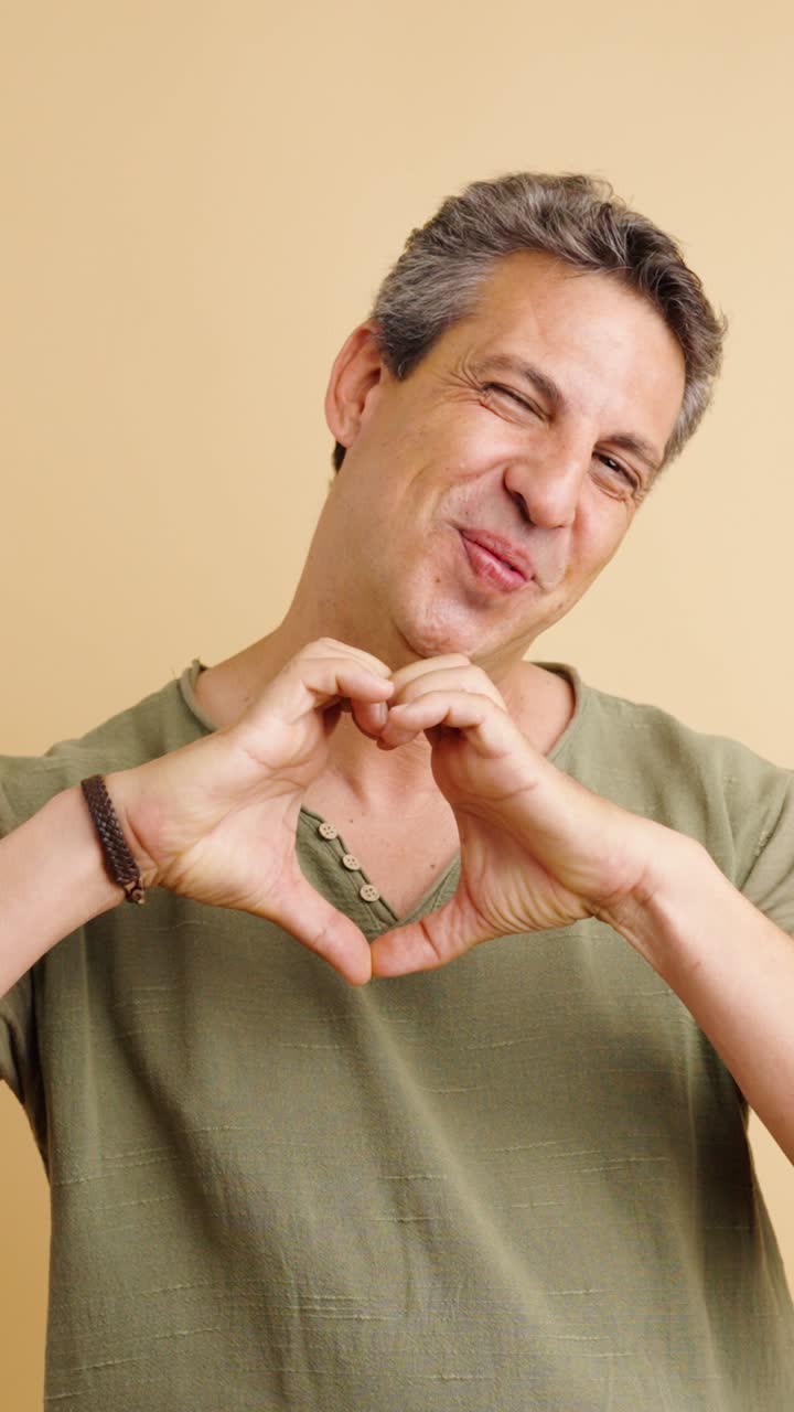 Portrait of a Smiling Man Making Heart Shape with Hands