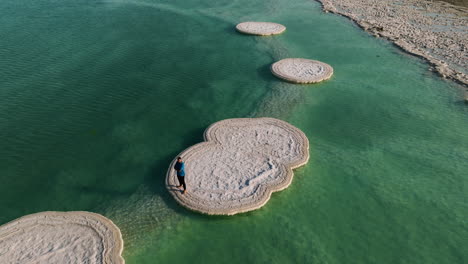 Famous-Salt-Islands-With-A-Tourist-Standing-On-The-Dead-Sea,-Israel