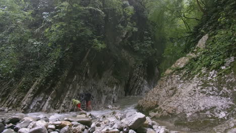 hikers crossing a mountain stream in a canyon