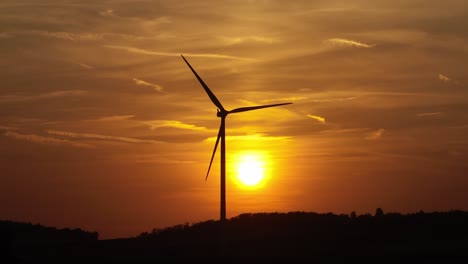 turbina eolica in silhouette contro un tramonto dorato