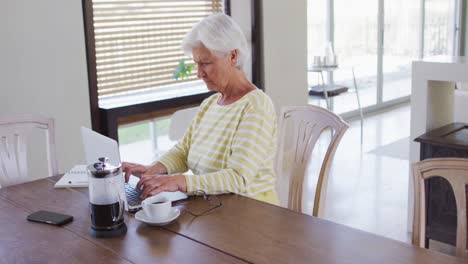 Mujer-Caucásica-Mayor-Usando-Una-Computadora-Portátil-En-La-Sala-De-Estar-En-Casa