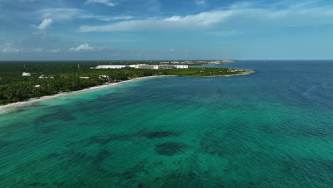 Aerial-overview-of-the-sunny-shoreline-of-Xpu-Ha,-Mexico---rising,-drone-shot