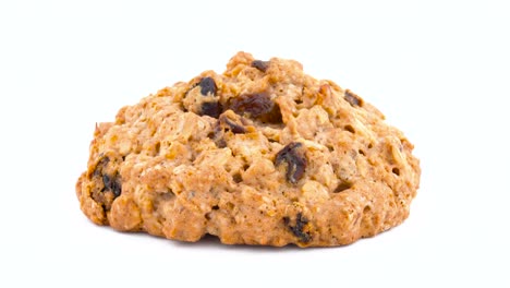 macro of a full frame one oatmeal raisin cookie rotating on the turntable. isolated on the white color background.