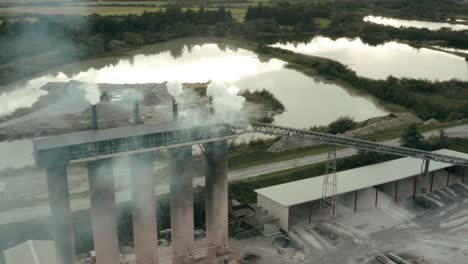 volando alrededor de edificios de fábricas que fuman