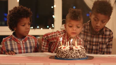 kids blowing cake's candles out.