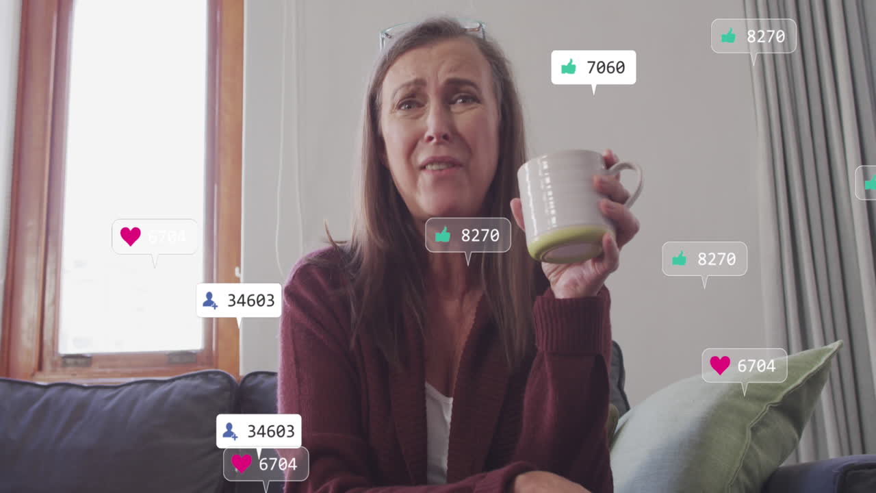 animación de texto e iconos de redes sociales sobre mujer caucásica con una taza de té en casa