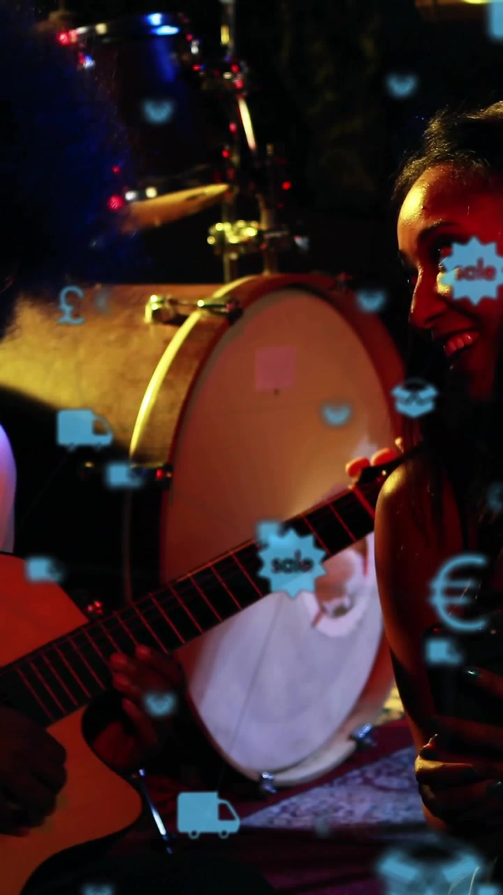 Video verticale: Chitarrista che suona, donna con telefono, icone che fluttuano sulla chitarra promuovendo la musica
