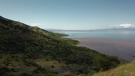 hermosa toma de dron de 4k de excursionistas escalando una montaña en tanzania con la ayuda de algunos sherpas africanos, mostrando detrás de un hermoso paisaje colorido