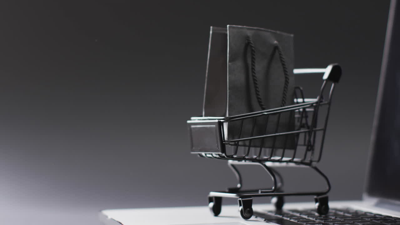 video de portátil con pantalla en blanco, bolsa de compras y carrito con espacio de copia sobre fondo blanco