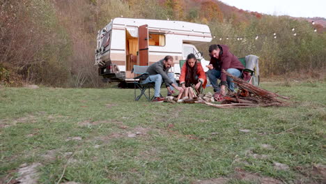 group of friends getting the fire ready for the night