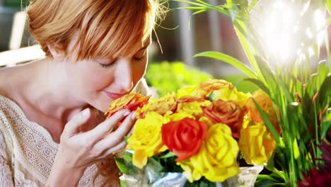 beautiful female florist smelling roses