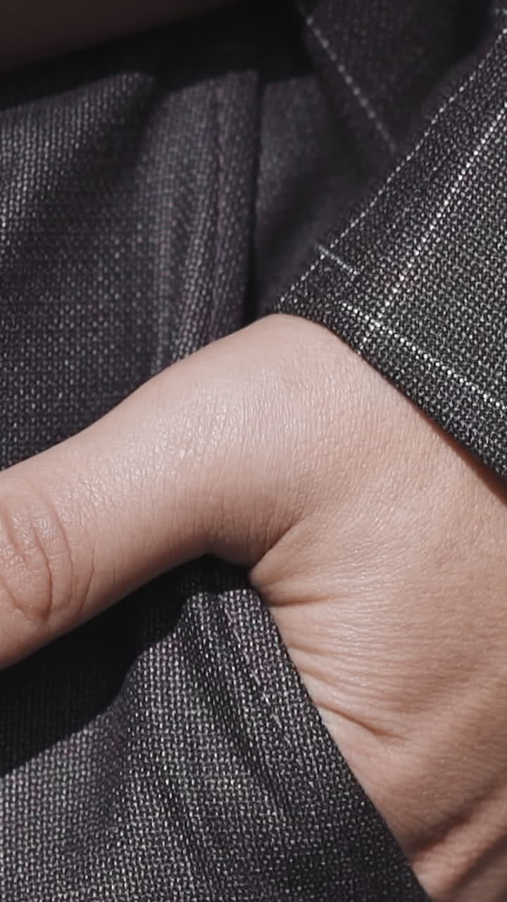 Businessman in office suit puts hand into trousers pocket on city street close view slow motion. Stylish man walks along park. Business casual clothes