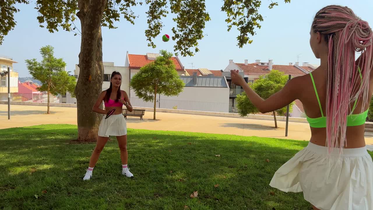 Two women play frisbee in the park