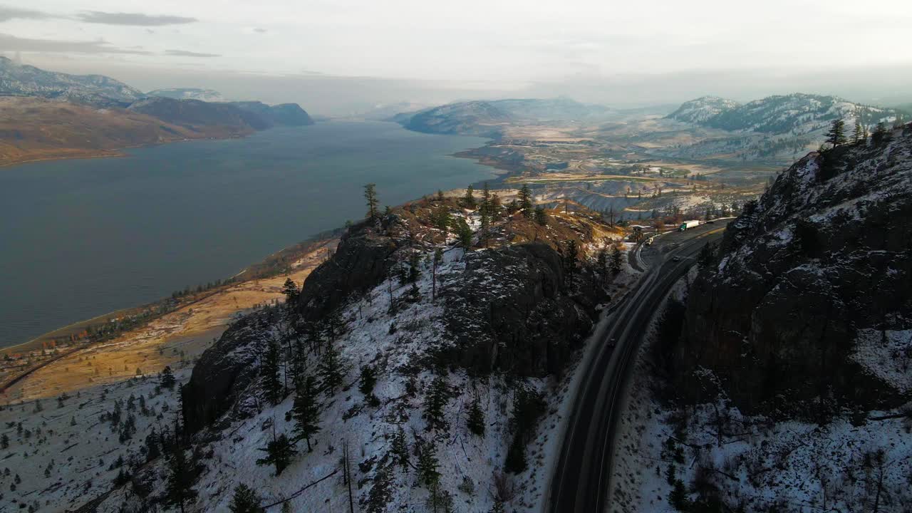 autopista 1 a la sombra que atraviesa colinas rocosas junto al lago kamloops en invierno, maravillosa luz dorada sobre un paisaje desértico parcialmente cubierto