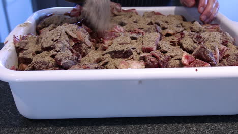agregar especias y agua a la carne picada en un recipiente rectangular antes de mezclar con las manos - hacer salchichas - cerrar