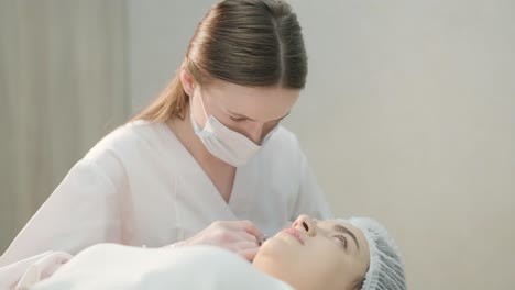 mujer que se somete a un tratamiento facial en una clínica de cosmetología