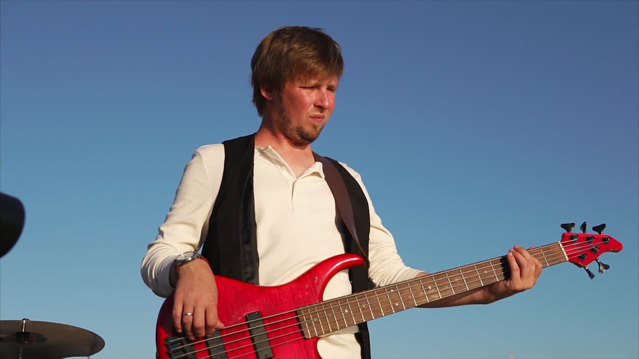 Man Playing Red Bass Guitar