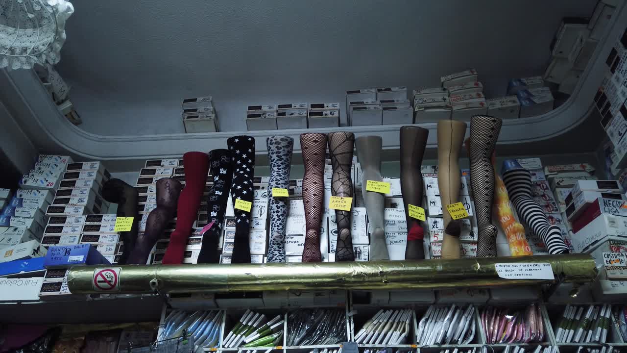 A panning shot from below of mannequin legs with stockings in a small shop