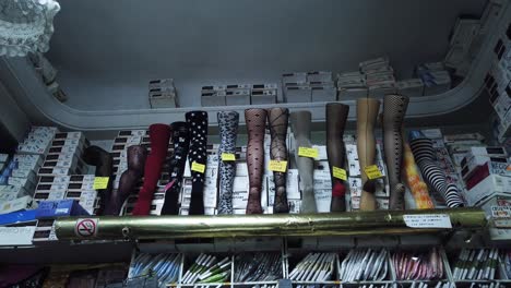 a panning shot from below of mannequin legs with stockings in a small shop