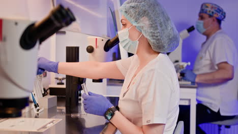 laboratory technicians working with microscopes and equipment